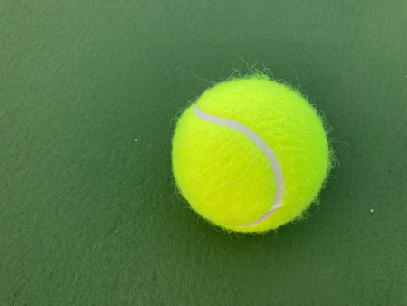 Very close-up shot of a single tennis ball placed on a tennis courtの写真素材