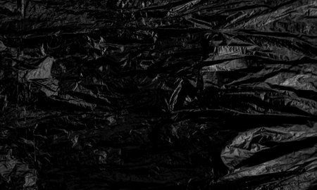 Black plastic bag texture, wrap texture on a black background wallpaper, wrinkled plastic pattern for creative and decorative design.の写真素材