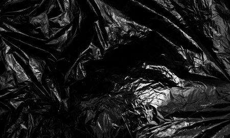 Black plastic bag texture, wrap texture on a black background wallpaper, wrinkled plastic pattern for creative and decorative design.の写真素材