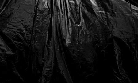 Black plastic bag texture, wrap texture on a black background wallpaper, wrinkled plastic pattern...