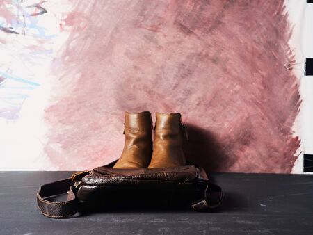 pictured are brown stylish boots and accessories. It can be a suitcase, bag or gloves. Background in...