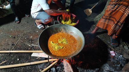 Unidentified people cooking curry in a cauldron.の写真素材