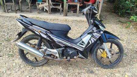 Rear view of a black and white motorcycle on the ground.の写真素材