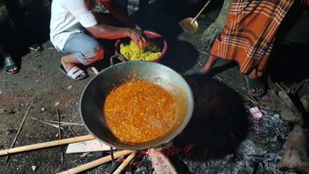 Unidentified people cooking rice in a wok.の写真素材