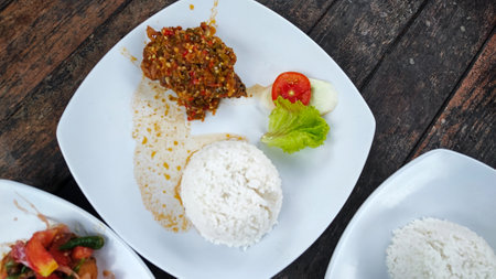 Thai spicy salad with rice in white plate on wooden table.の写真素材