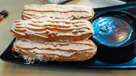 Close up of a stack of delicious eclairs with powdered sugarの写真素材