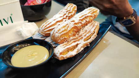 Eclairs with custard cream on the table in a cafe
