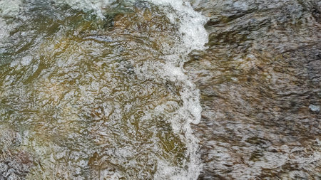 Water flowing down the rocks in the river, closeup of photoの写真素材