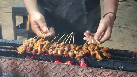 Grilled pork on the grill in a street food market in Thailandの写真素材