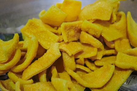 Dried mango slices in a metal container, closeup of photoの写真素材