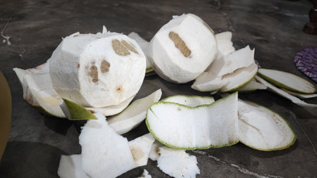 Coconut fruit cut in half on the marble floor background.