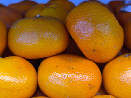 Fresh, vibrant bright orange tangerines with textured skins are closely arranged, highlighting their natural appearanceの写真素材