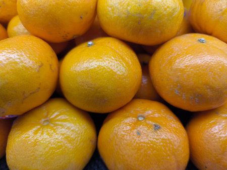 Close up view of fresh, ripe orange tangerines with textured skins, stacked together and ready for consumption Healthy citrus fruitsの写真素材