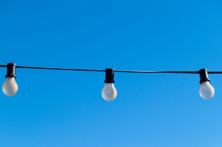A set of light bulbs against a clear blue sky.の写真素材