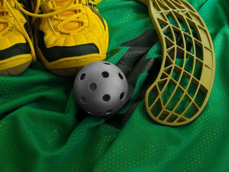Floorball ball, stick, and shoes on a green jersey.の写真素材