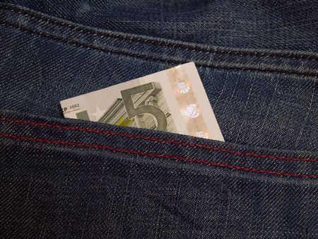 A five euro bill in the back pocket of jeans.の写真素材