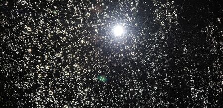 raindrops on glass at night from the roomの写真素材
