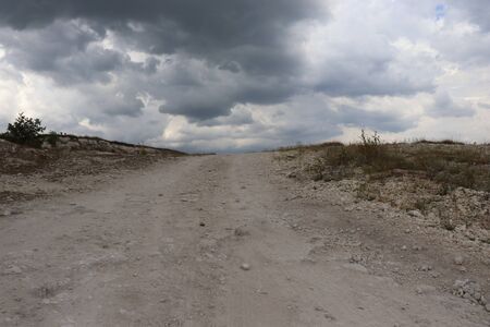 road to the clouds, light, green grass on the side of the road, the moon in the skyの写真素材