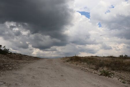 road to the clouds, light, green grass on the side of the road, the moon in the skyの写真素材