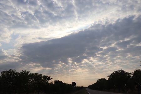 the sun through the gray clouds in the eveningの写真素材