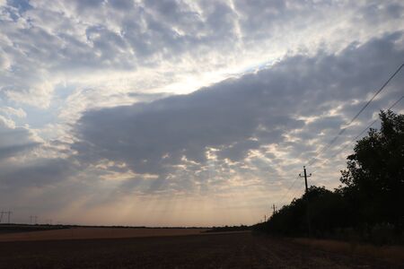 the sun through the gray clouds in the eveningの写真素材
