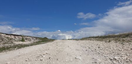 road to the clouds, light, green grass on the side of the road, the moon in the skyの写真素材