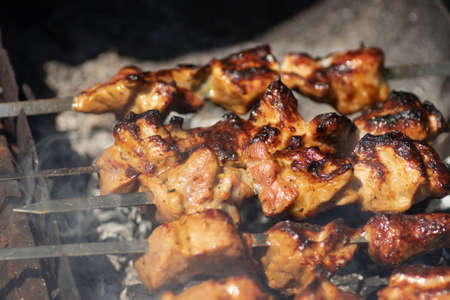 appetizing grilled meat on skewers on a sunny day baked in the grillの写真素材