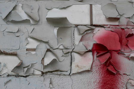 shabby burnt peeling paint on a brick wall