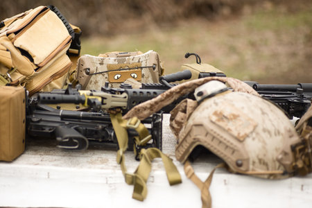 airsoft replica weapon and top camouflage helmet AOR 1, machine gun on a natural background