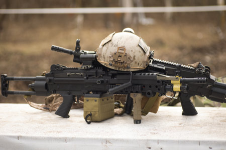 airsoft replica weapon and top camouflage helmet AOR 1, machine gun on a natural background