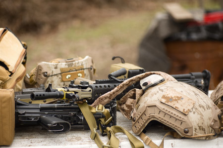 airsoft replica weapon and top camouflage helmet AOR 1, machine gun on a natural background