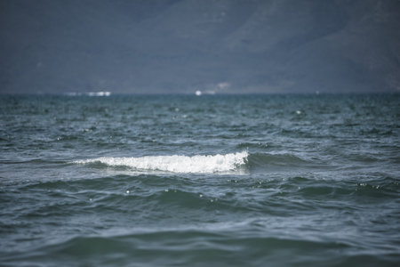 Sea Waves and Distant Mountainsの写真素材