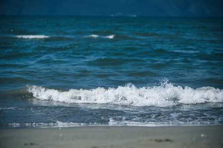Sea Waves and Distant Mountains Under Wildfire Haze â August 23, 2025の写真素材