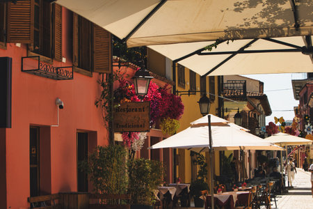 A vibrant midday scene in the old town of VlorÃ«, Albania, rustic shutters, and lively tourist streets come together under the intense summer heat on August 20, 2025.のeditorial素材