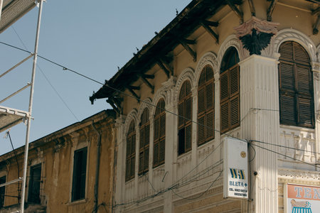 A vibrant midday scene in the old town of VlorÃ«, Albania, rustic shutters, and lively tourist...