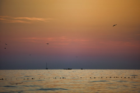 Vlora, Albania â€“ August 24, 2025: Vibrant sunset over the Adriatic Sea with rolling waves and...