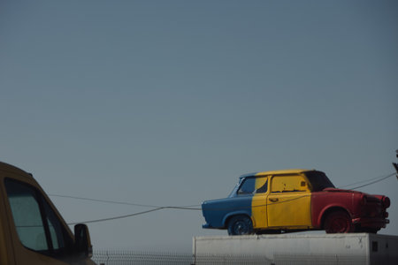 Colorful vintage car sculpture displayed outdoors against a clear sky, photographed along the road during a summer journey in August 2025.のeditorial素材