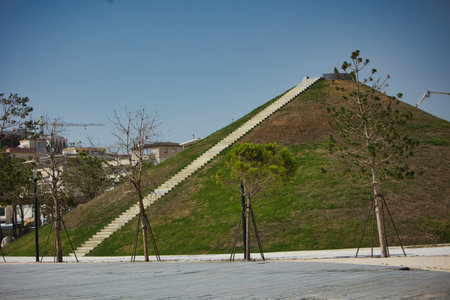 VlorÃ«, Albania â August 21 2025: A large landscaped hill with a long staircase leading to the top, surrounded by young trees and urban development,の写真素材
