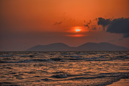 Vlora, Albania â August 21, 2025: A serene sunset over the Adriatic Sea, with warm golden light reflecting across gentle waves and distant silhouettes of mountains.の写真素材