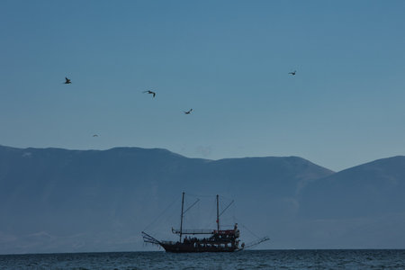 VlorÃ«, Albania August 2025 A tourist boat sails across the calm blue sea with distant mountains...