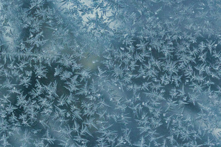 Abstract winter frost texture with delicate ice crystal patterns on a frozen surface