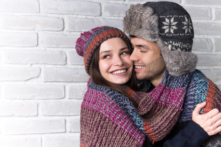 Happy young couple hugging in warm clothesの写真素材