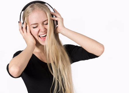 Young Woman Listening to Music on Headphones and Sings. Copy Spaceの写真素材