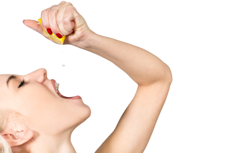 Woman is Drinking Juice of a Lemon Isolated on White Backgroundの写真素材
