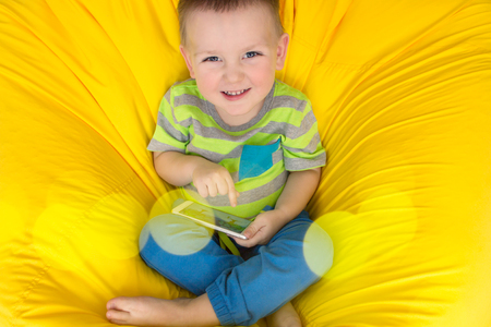 Happy Little Boy with a Gadget in Handsの写真素材