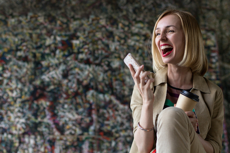 Joyful Woman with Phone and Coffee. Copy Spaceの写真素材