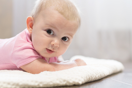 Playful Little Baby Lies on Belly. Copy Spaceの写真素材
