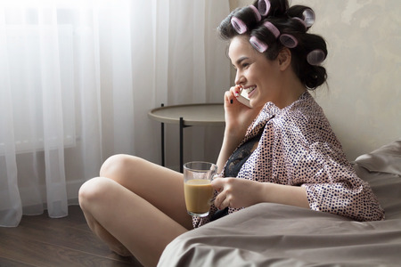 Beautiful Woman Talking on Phone and Drinking Coffee. Copy of Spaceの写真素材