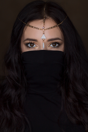 Eastern Beautiful Brunette Woman on Dark Backgroundの写真素材