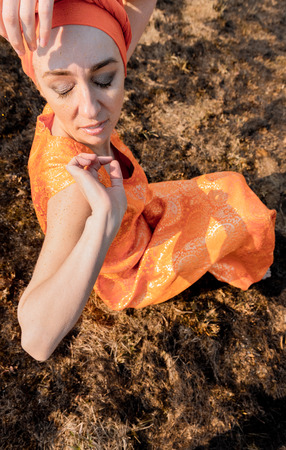 Woman in Eastern Clothing. Sprinkles itself with Gold Sequins. Emotional Portretの写真素材